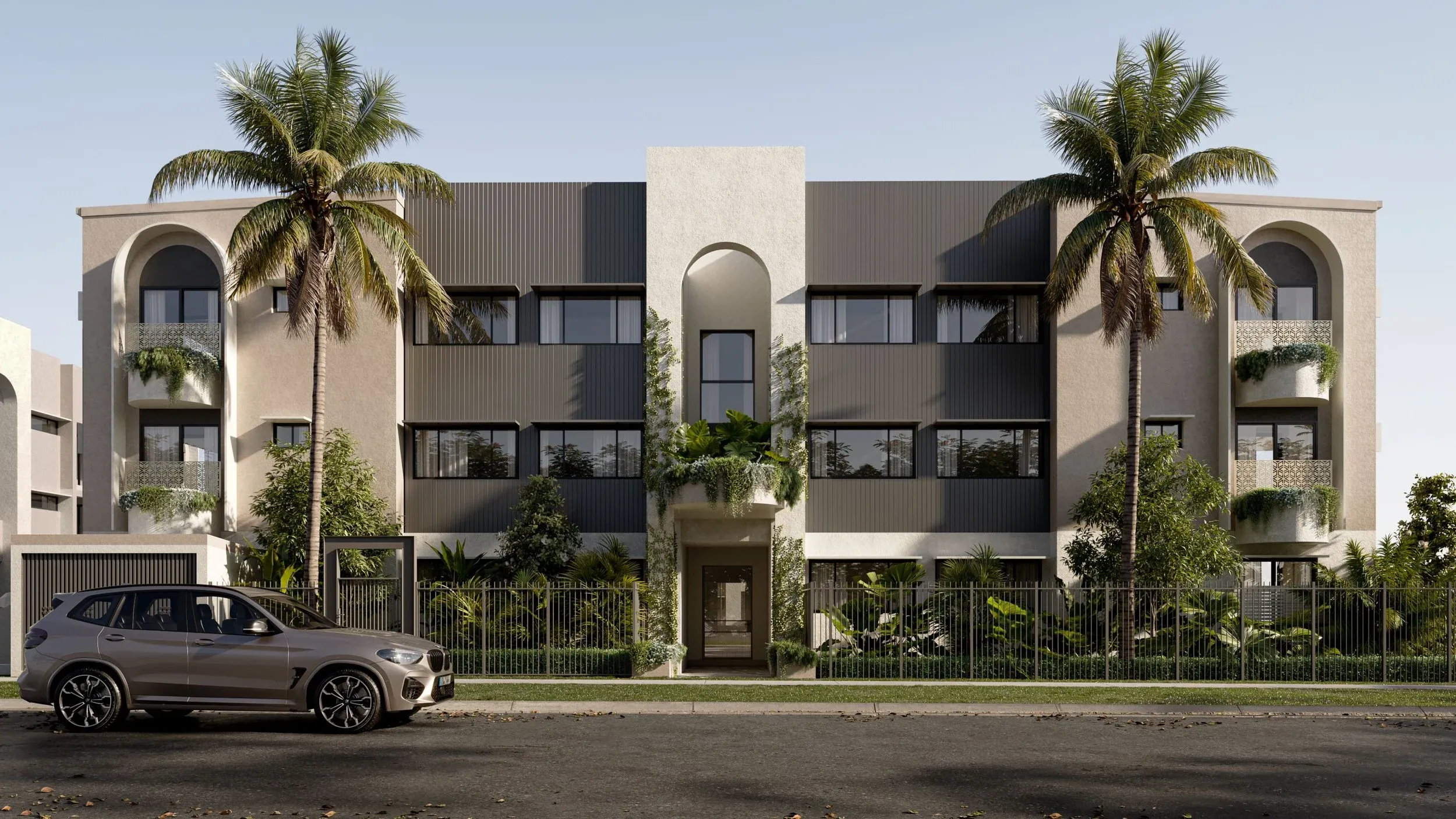 Render of Arca Stafford, arched low-rise apartment buildings in warm render behind palms and layered tropical planting