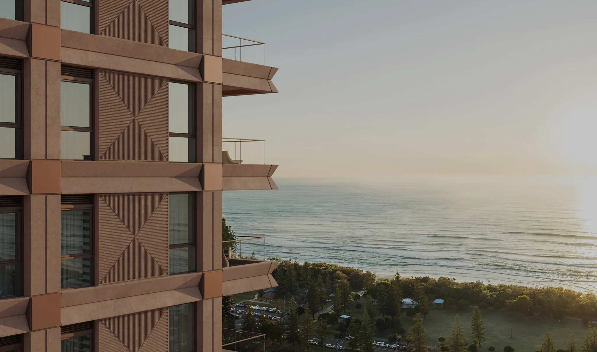 Render of The Eveleigh Broadbeach facade in warm terracotta tones, balconies looking over the beach and open Pacific at first light